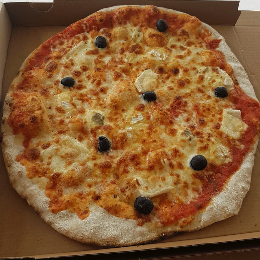 Une pizza aux fromages et aux olives dans son carton.